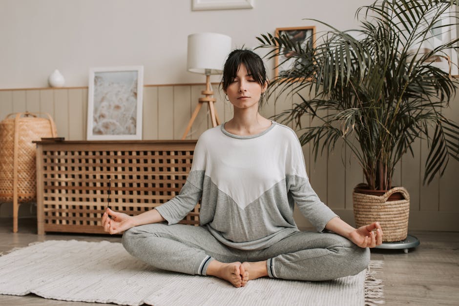 Woman meditating peacefully in a cozy room with soft light.